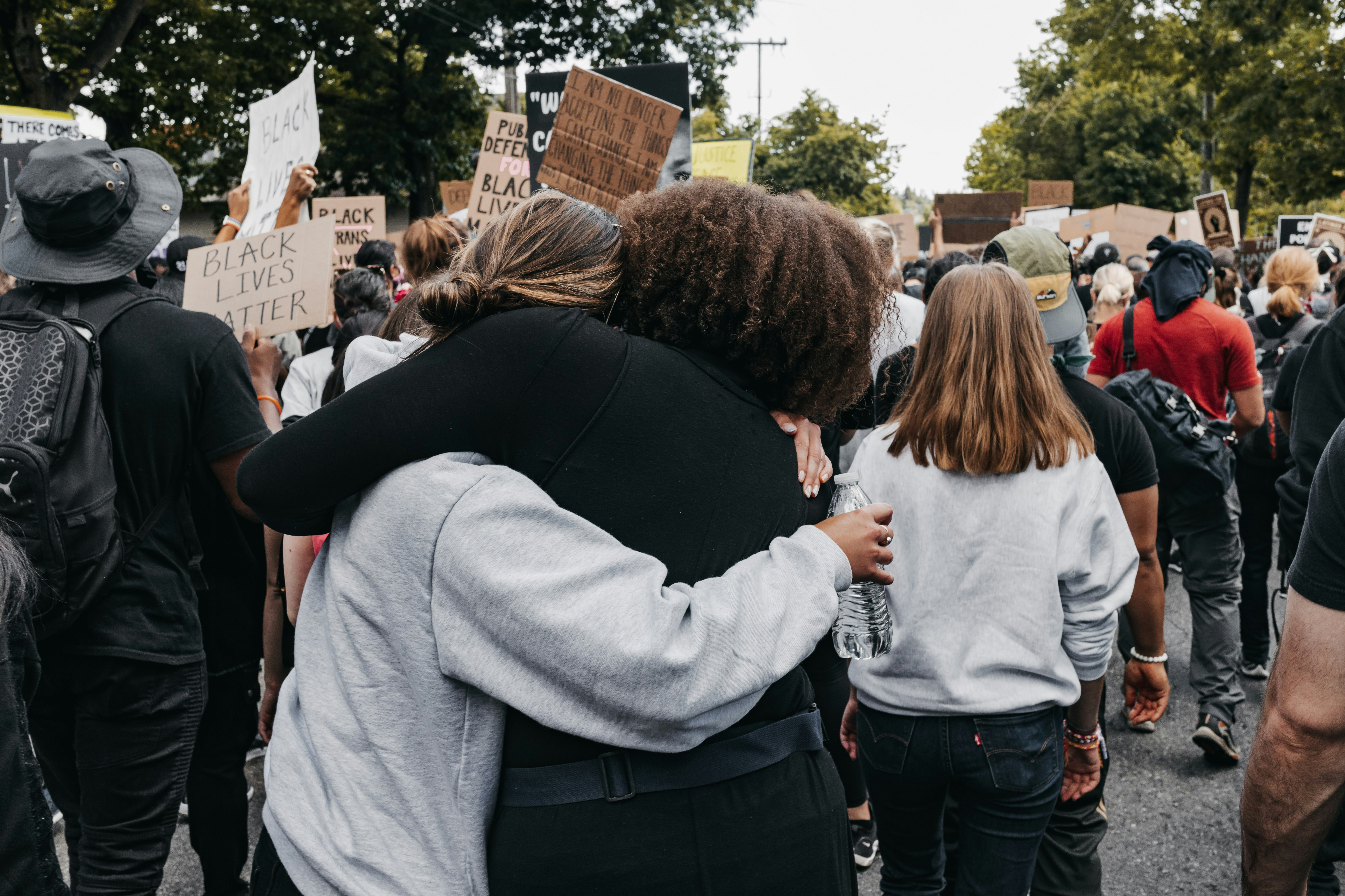 Image of two people embracing at a protest.