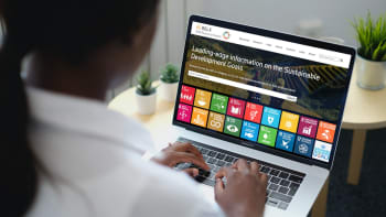 Person typing on laptop with SDG Resource Centre displayed